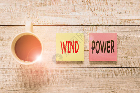 手写文字书写风力概念照片使用气流来提供机械动力来转动发电机固定放置在木桌上方的一图片