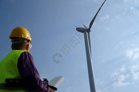 风力涡轮机的工程师一名戴头盔的男子在监督电动风车的运行生态和可图片