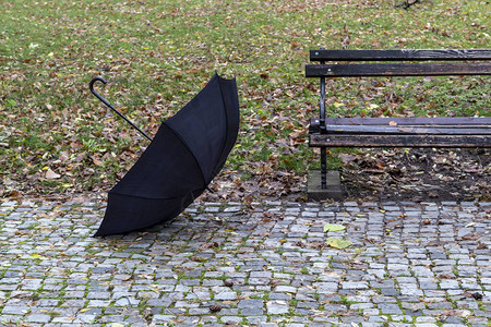 漂浮在公园的黑伞和长凳背景图片