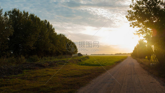 明亮的阳光升起在阴云的天空上在有碎石通图片