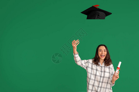 具有颁发彩色背景帽子文凭的毕业女图片