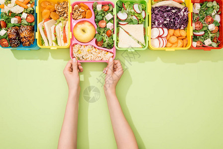 女选择绿色背景食物午餐盒的剪影图片