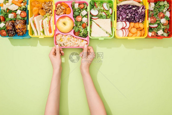 女选择绿色背景食物午餐盒的剪影图片