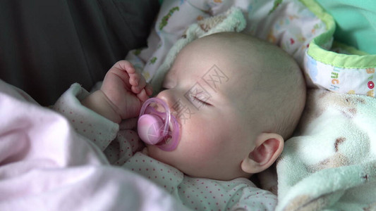婴儿在婴儿车的嘴里用奶嘴睡图片