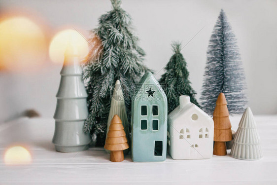 圣诞小房子和树木与白色上的灯光散景的现代装饰节日快乐微型舒适的村庄图片