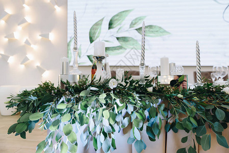光室中绿叶和银蜡烛的装饰组合物背景图片