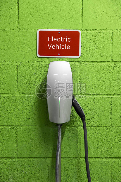 绿色墙上的电动汽车充电器图片