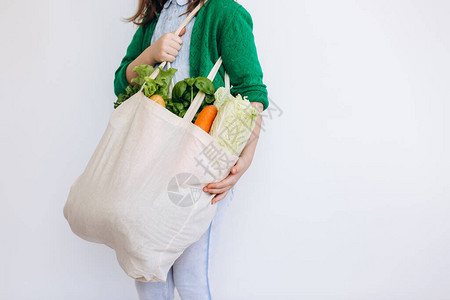 小女孩拿着带有蔬菜的纺织食品袋零废物概念包食品购物有机水果和蔬菜图片