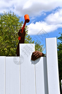 一名工人在新后院的私隐栅栏上把一块板图片
