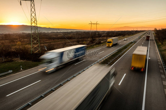 送货卡车和汽车在高速公路上高速行驶图片