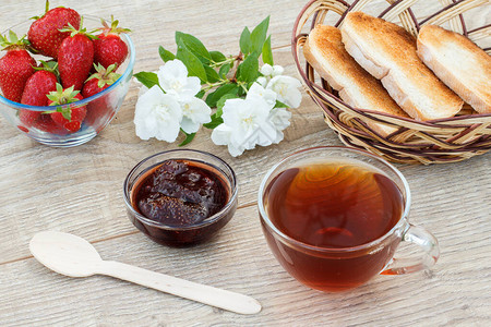 杯茶自制草莓果酱新鲜草莓勺子烤面包和木本底的白茉莉图片