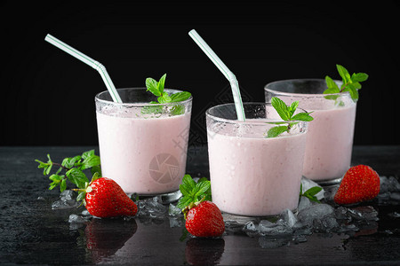 桌上有一杯新鲜草莓奶昔冰沙或奶昔和新鲜草莓多汁水果的健康食图片