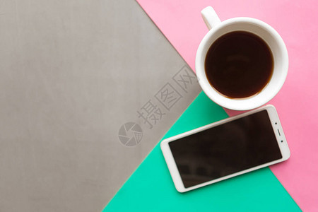 彩色背景的咖啡杯和模拟电话复制文本空间最小概念图片