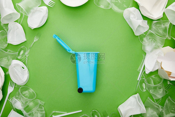 压碎塑料杯叉子板材和纸板容器之间绿色的蓝图片