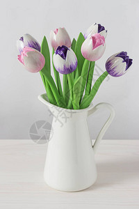 木制郁金香人造花粉红色紫罗兰装在一个白色的罐子里图片