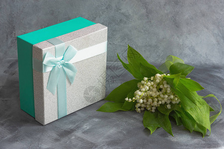 一束山谷的百合花和一盒礼品图片