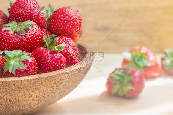 木碗中的新鲜美草莓木桌图片