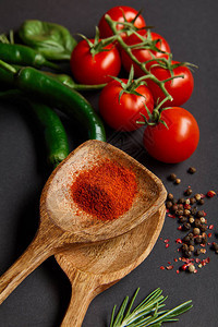 红樱桃西红柿迷迭香胡椒玉米配辣椒粉的木勺子图片