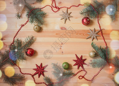 圣诞框架由木质背景上的圆形树枝和多彩的圣诞节装饰组成顶部视图片