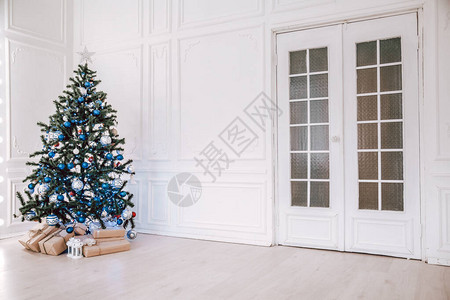 圣诞树在白色房间的蓝色圣诞树和圣图片