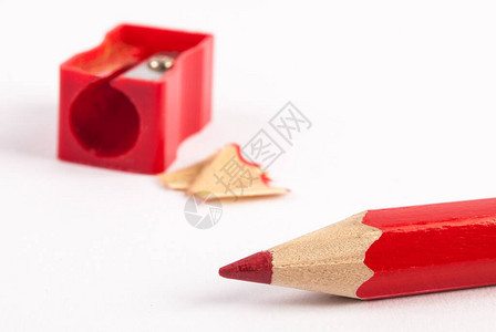 白色背景上的卷笔刀和红色木制铅笔图片