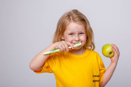 有牙刷的小女孩有牙刷和苹果的小女孩日常卫生的概念在白图片