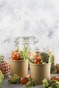 一次环保食品包装中的健康食品蓝色背景上棕色纸食品容器中的蔬图片