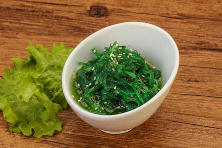 在白色背景顶视图上隔离的绿色Chuka海藻沙拉裙带菜海带沙拉图片