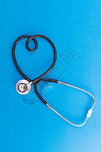 蓝色背景中心形听诊器医学概念与爱的象征关图片