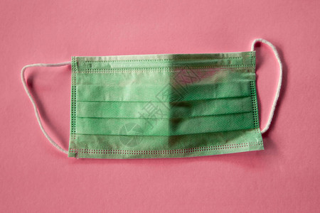 粉红色背景上的绿色医用口罩图片