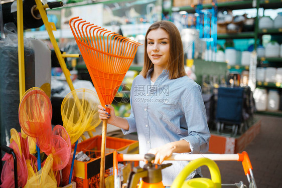 女顾客在货架上挑选园艺工具图片