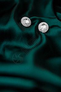 珠宝品牌优雅时尚和新娘奢华礼物概念深翡翠绿丝绸上的豪华钻石耳环节日图片