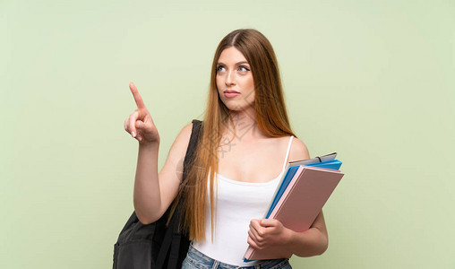 年轻女学生在孤立的绿色背景上图片