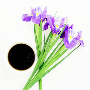 白色背景上带咖啡杯的紫色鸢尾花顶视图图片