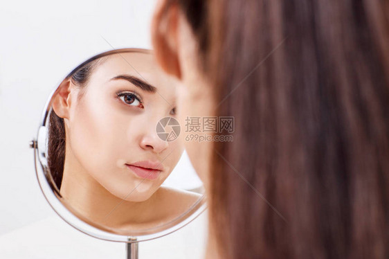 眼睛有青肿的年轻女人在镜子里图片