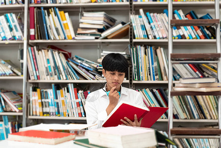 青少年在图书馆以感兴趣的感觉从书本中查找资料图片