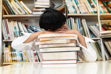 年轻青少年在图书馆搜寻资料时睡觉周图片