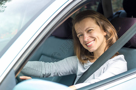 微笑的女驾驶员坐在车里背景图片