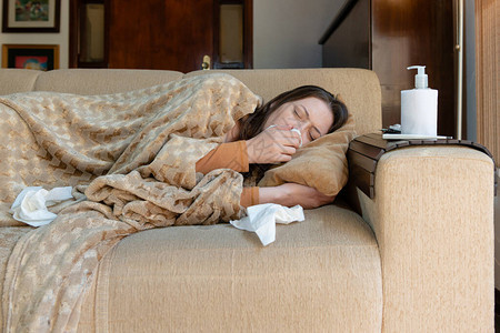 女人躺在沙发上感冒很重图片
