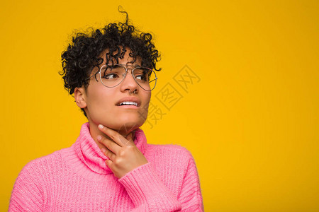 身穿粉色毛衣的年轻非洲女因或感染而喉咙疼痛图片
