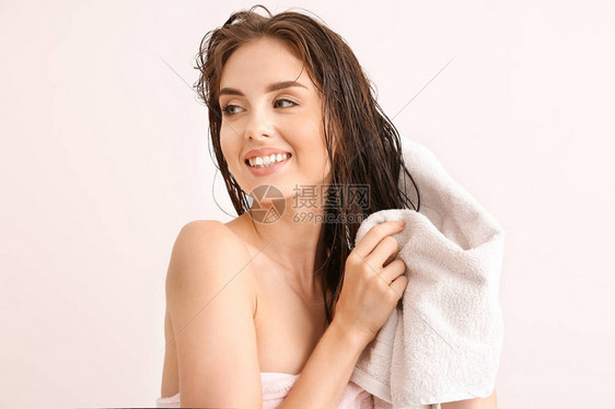 美丽的年轻女子洗完头发后在浅图片