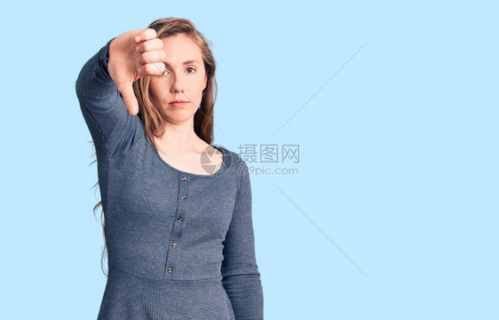 身着散装服的年轻金发美女看上去很不开心很生气表示拒绝和否定手势低下拇图片