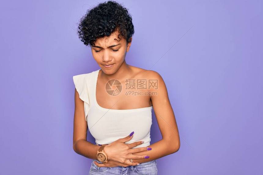 年轻漂亮的非洲裔美国黑人女穿着紫色背景的休闲T恤图片