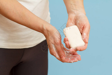 女人用蓝色背景上的肥皂洗手正确清洁双手可以防止感染卫图片