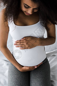 African孕妇坐在床上时触摸肚图片