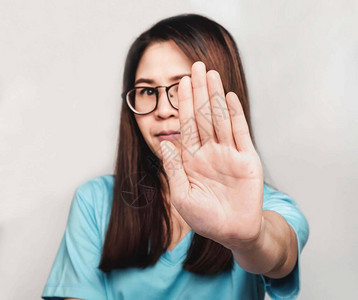 人们做手势年轻美丽的亚洲女人戴着眼镜和蓝色T恤图片