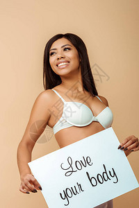快乐的非裔美国女孩拿着标语牌爱着你的身体在蜜蜂背景图片