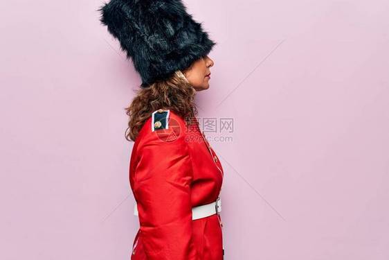 中年美丽的威尔士守卫妇女身穿粉红色背景的传统制服图片