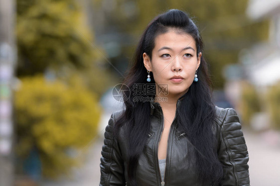在街上露天穿着皮夹克的亚洲反抗妇女肖像图片