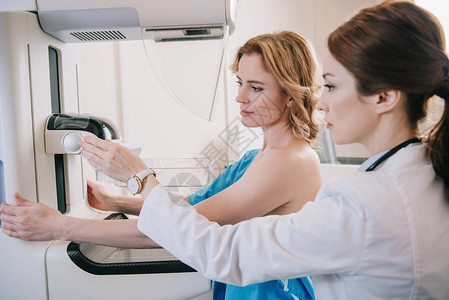 在靠近病人时调整X射线机进行乳腺造影检查图片